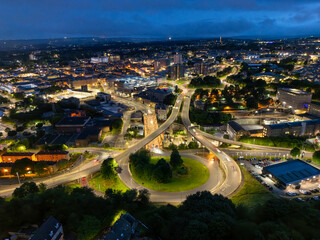 An evening aerial view showcasing a bustling cityscape at night, with roads and buildings...