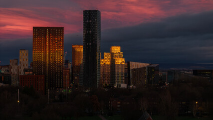 Fototapeta premium Stunning sunset view reflecting off modern buildings, creating a mesmerizing display of light and color that highlights the architectural beauty of the urban landscape.