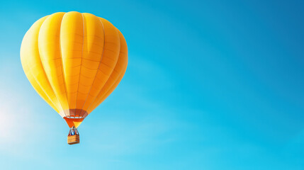 Fototapeta premium vibrant yellow hot air balloon floats against clear blue sky, creating cheerful and uplifting scene. balloon bright color contrasts beautifully with serene backdrop