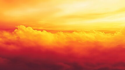 Obraz premium A vibrant sunset over clouds, showcasing warm orange and yellow hues.