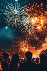 A crowd watches a vibrant fireworks display lighting up the night sky.