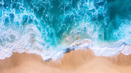 Aerial view of ocean waves crashing on sandy beach.