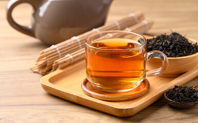 Black tea in cup glass with dried tea leaves, Healthy herbal drink