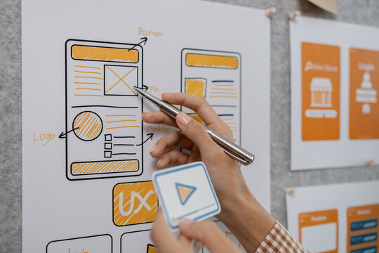 ux developer and ui designer brainstorming about mobile app interface wireframe design in the office, website designer, creative planning phone app development template - Powered by Adobe
