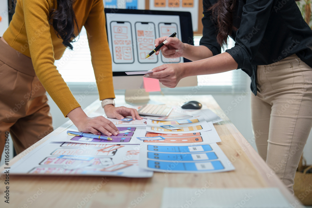 Poster two female ux ui designers are discussing mobile app templates, working together to enhance user exp