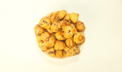 Choux Pastry with chocolate filling inside served with a bowl isolated on a white background. Chocolate choux pastry is round in shape