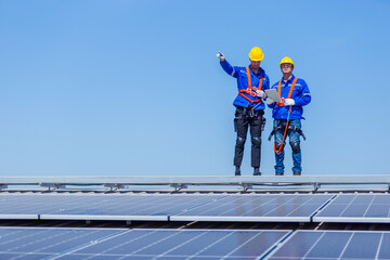 Technicians installing and inspecting standards solar panels on roof industrial factory. Shake hand...