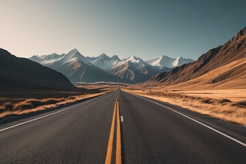 Fototapeta premium there is a long road going through the mountains with a yellow line