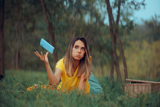 Woman Throwing Away Phone Giving up Technology Addiction. Lady feeling fed up with her smartphone trying to relax outdoors
