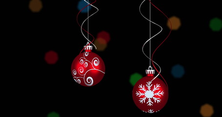 Image of christmas red baubles and fairy lights flickering over black background