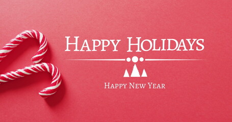 Image of christmas greetings text over christmas candy canes and decorations