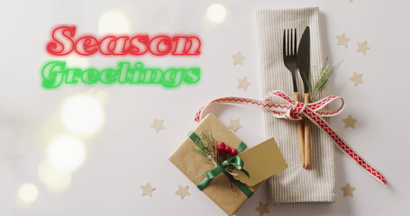 Image of christmas greetings text over christmas place setting and decorations © vectorfusionart