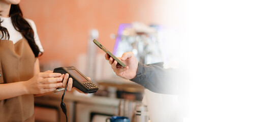 Barista facilitating a contactless payment using a card reader and smartphone. Capturing modern...