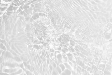 White water with ripples on the surface. Defocus blurred transparent white colored clear calm water surface texture with splashes and bubbles. Water waves with shining pattern texture background.