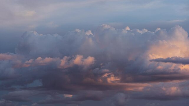 Time-lapse footage of the clouds moving in the blue dusk sky at sunset