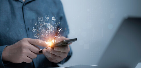 A man holds a smartphone displaying global connections with technology-related icons. Represents global communication, networking, and technological advancements through smart devices and innovation