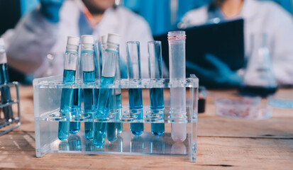 Blood test in the laboratory. Laboratory assistant working with the dispenser. Vacuum tubes with blood.