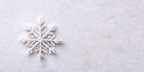 A delicate snowflake resting on a white surface, showcasing intricate patterns and the beauty of winter's natural artistry.