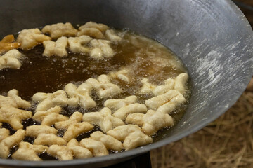 Chinese bread stick or chinese donut deep fry in a pan. Breakfast street food usually eat with hot tea, coffee or soy milk.