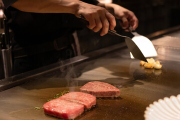 Grilled meat sizzling on a hot plate.