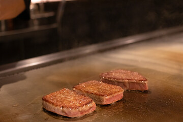 Grilled meat sizzling on a hot plate.