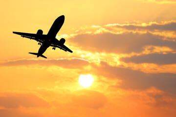 Airplane Silhouette Against Vibrant Sunset Sky with Dramatic Clouds in the Background Capturing the Essence of Travel and Adventure