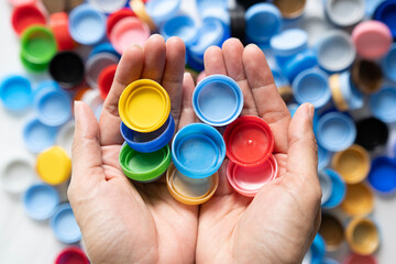 Woman hand holding plastic bottles caps for recycling to conserve the environment, Recycling, reuse, garbage disposal, save the world concept.