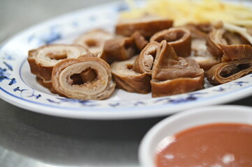 Braised large intestines, a Taiwanese favorite, feature a tender texture and aromatic flavor. Ginger strips remove the odor, while dipping sauces add extra dimension to every bite.