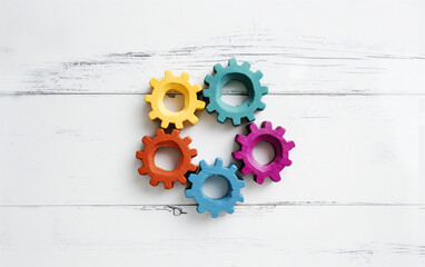 Set of five vibrantly colored wooden gears arranged in a connected pattern on a white wooden surface. Collaboration, integration, innovation, teamwork, and creative problem-solving.