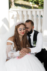 couple in wedding dresses. The woman is wearing a white wedding dress with long sleeves made of...
