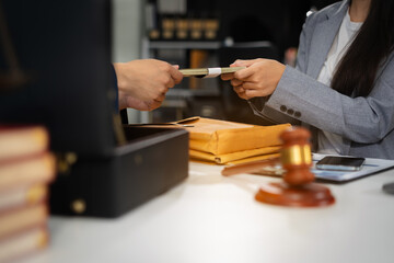 Businessman giving bribe money in the envelope to partner in a corruption scam in office.