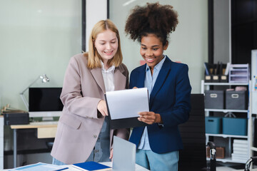 Diverse professionals collaborate on project analysis with financial graphs. Strategic teamwork and insights drive company growth and success.