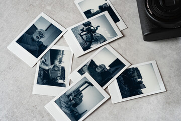 Collection of black and white polaroid pictures on a textured surface