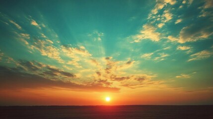 Obraz premium A serene sunset over a vast landscape with colorful clouds.