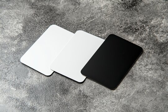 Minimalist Display of Three Blank Cards on a Textured Gray Background for Mockup and Design Usage, Offering Versatility for Various Creative Projects