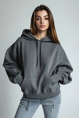 Young Woman in Gray Hoodie Posing Against Light Background