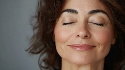 Smile, eyes closed and skincare of mature woman in studio for glow, results or beauty on gray background