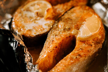 Baked trout steak with lemon showcasing tender, flavorful meat and aromatic herbs after being cooked over an open flame