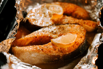 Delicious trout steak baked in lemon sauce in an oven, showcasing flavorful grilled fish preparation