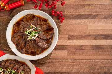 Taiwanese braised beef shank slices in a plate on wooden table background.
