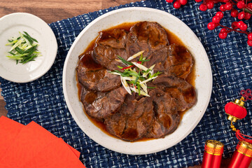 Taiwanese braised beef shank slices in a plate on wooden table background.