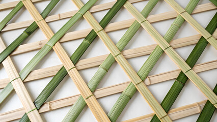 Eco backgrounds. A simple and natural bamboo weaving pattern, featuring light and green bamboo strips arranged in a diagonal lattice, showcasing traditional craftsmanship.