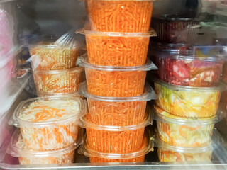 Plastic containers with sauerkraut and carrots are in the fridge. Pickling cabbage for winter. Pickles. Fermented vegetables.