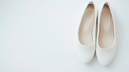 Fototapeta premium Stylish white flat shoes elegantly positioned on a clean white background for fashion and lifestyle concepts