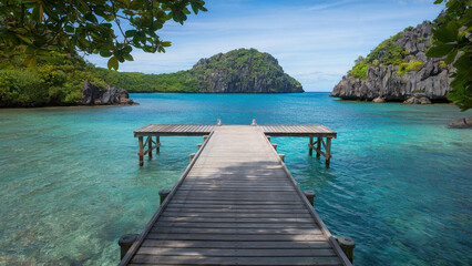 Fototapeta premium Wooden pier is in front of a body of water