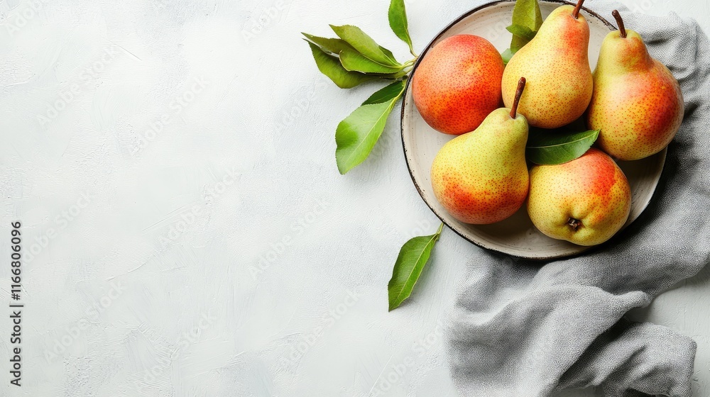 Poster fresh ripe pears arranged on a plate with green leaves on a light background inviting space for text