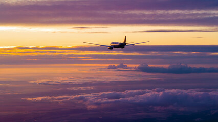 Plane is flying through the sky with a beautiful sunset in the background