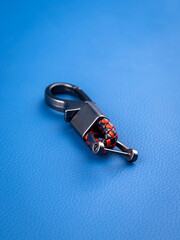 Close up of minimalist leather   keychain with metal fittings on blue background