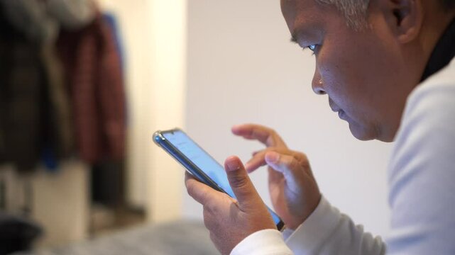 Hands holding smartphone pressing fingerers, reading social media internet, typing shopping online at home