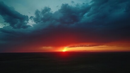 Obraz premium Fiery Sunset Over Dark Storm Clouds and Plains